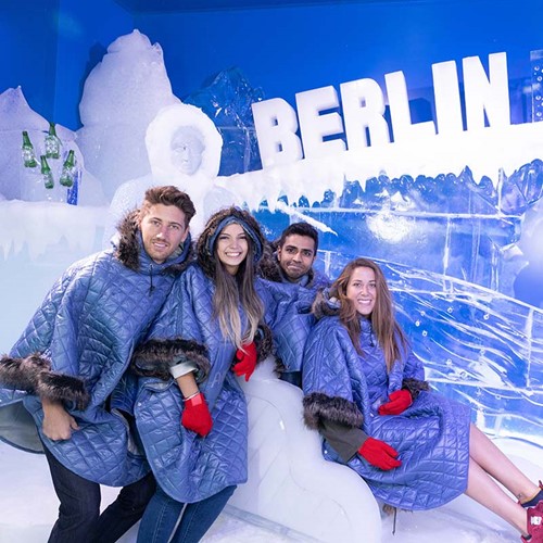 Four people posing on an ice sculpture at the Berlin Icebar. 